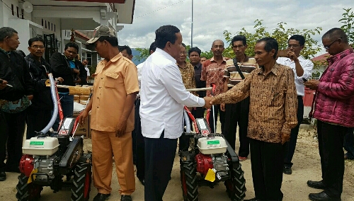 Foto : Secara simbolis, Bupati Samosir Drs.Rapidin Simbolon MM (kemeja putih) berikan alat pertanian Tractor Tangan kepada kelompok tani