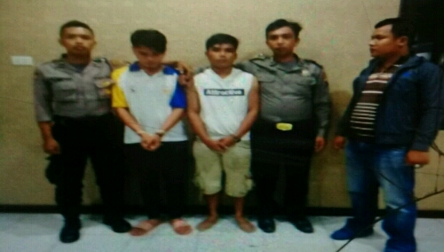 Foto : kedua pelaku (tengah pakai kaus putih) diapait petugas kepolisian, saat diamankan di Polsek Palipi Samosir Sumatera Utara