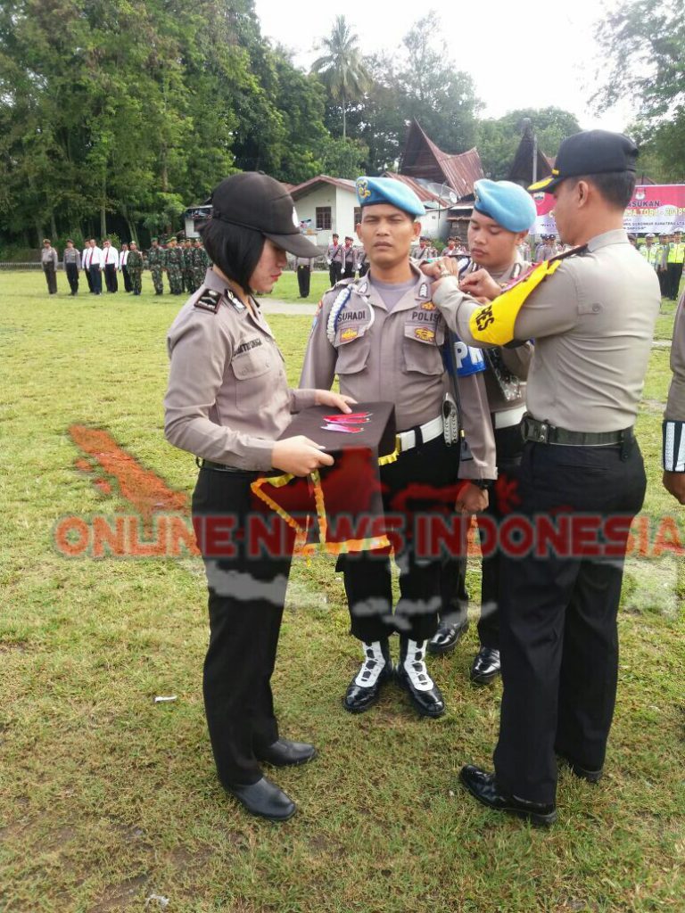 Foto : Kapolres Samosir, AKBP. Agus Darojat S.Ik MH, menyematkan tanda pita "Mantap Praja Toba 2018", kepada salah satu personil polisi