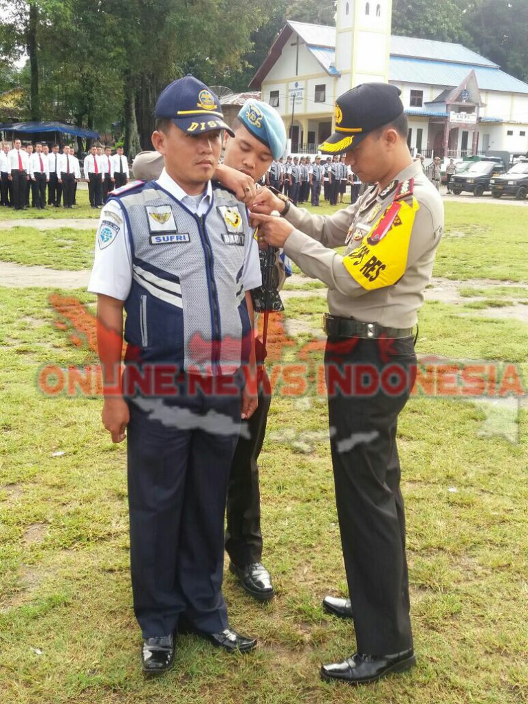 Foto: Kapolres Samosir, AKBP Agus Darojat S.Ik MH, menyematkan pita Ops "Mantap Praja Toba 2018" kepada salah satu personil Dinas perhubungan kabupaten samosir