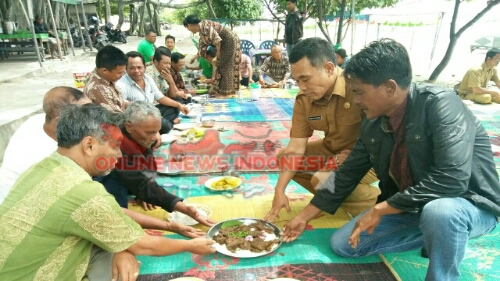 Foto : Kepala Dinas Pariwisata Samosir, Ombang Siboro (pakaian Dinas), sedang memberikan makanan kepada tokoh masyarakat, disela menggelar tonggo raja di Pantai Indah Situngkir, Kecamatan Pangururan, Selasa (20/3).
