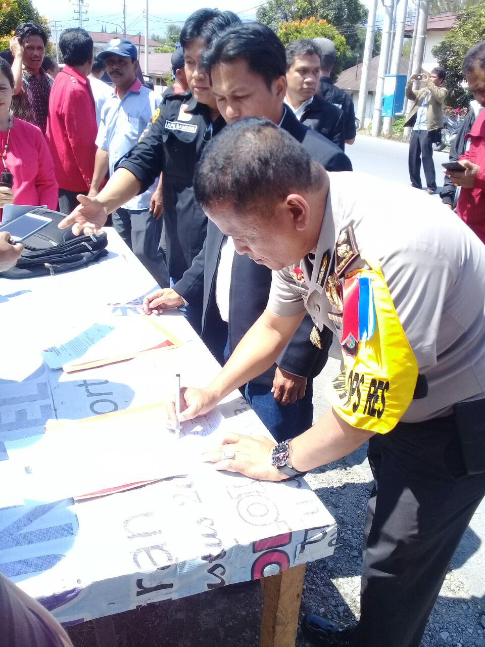 Foto : Kabag OPS Polres Samosir, Kompol.Bernard Naibaho, menandatangani beri acara kesepakatan pendirian Alat Peraga Kampanye (APK), diSimpan empat Pangururan Samosir