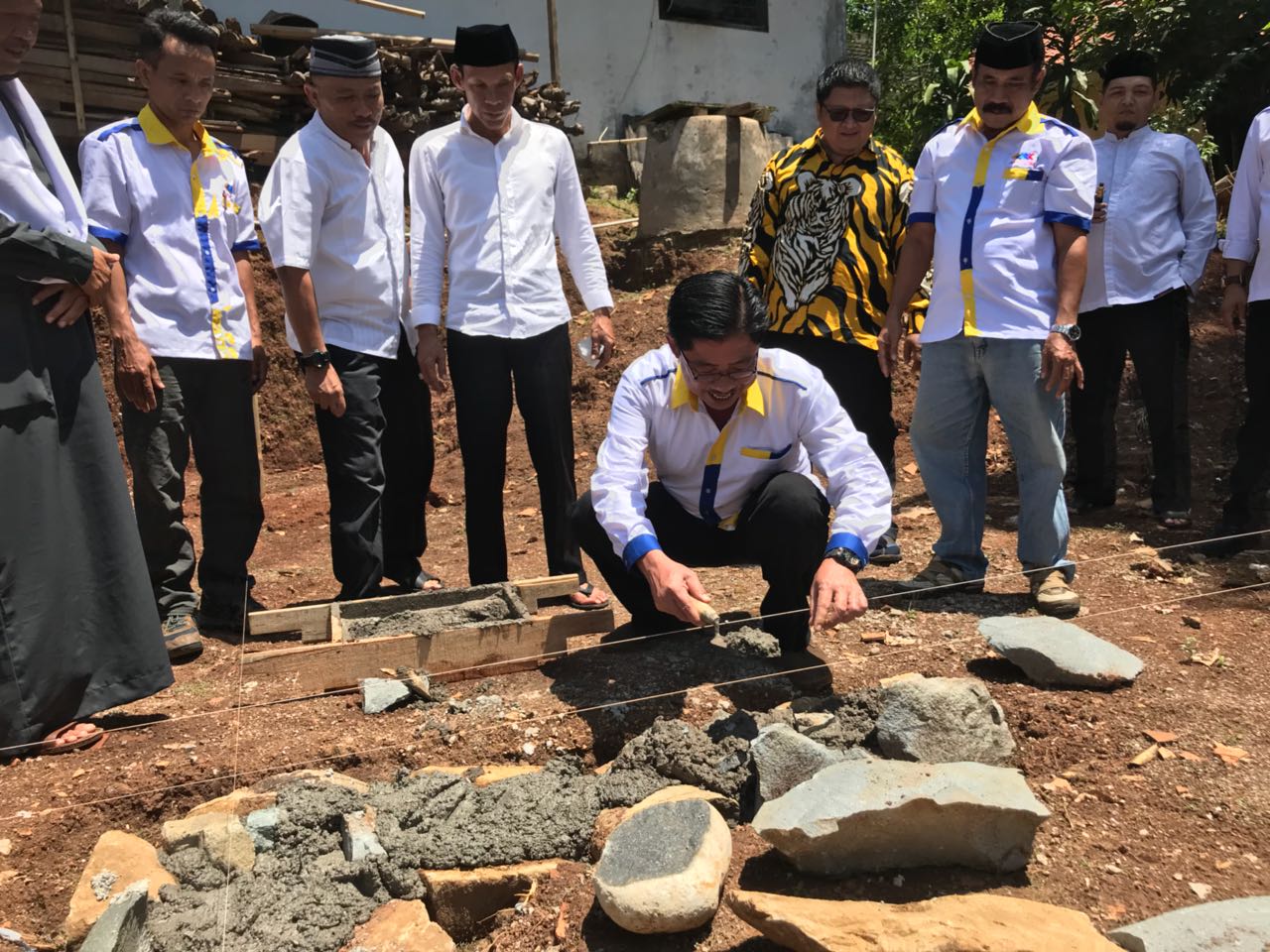 Foto : Sardi (jongkok) bersama calon bupati jaro Ade sedang melakukan peletakan batu pertama pembangunan pesantren di desa bendungan