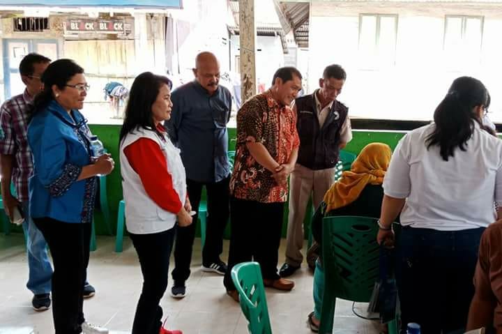 Foto : Bupati Karo (baju batik)tampak serius memperhatikan tim medis yang sedang melakukan pengobatan kepada pasien pada acara bakti sosial pengobatan gratis oleh Sat Brimob Polda Sumut.