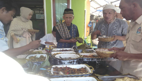 Salah satu anggota Panji Yosua (kanan) menikmati hidangan lebaran