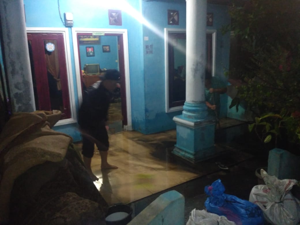 Ket foto : Salah satu warga membersihkan teras rumahnya yang kebanjiran sekitar pukul 17.30 Wib di Gang Rezeki Berastagi, Rabu, (19/09) 2018