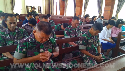 Personil TNI tengah berdoa di dalam gereja.