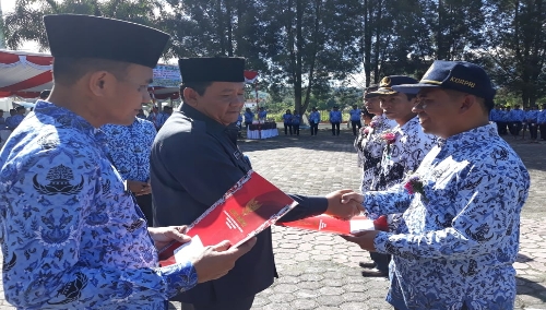 Foto : Bupati Samosir, Drs.Rapidin Simbolon MM, didampingi Kadis Pendidikan Samosir, Rikardo Hutajulu memberikan piagam penghargaan kepada Kepala Sekolah SMPN 1 Nainggolan EDISON SIMAMORA S.pd