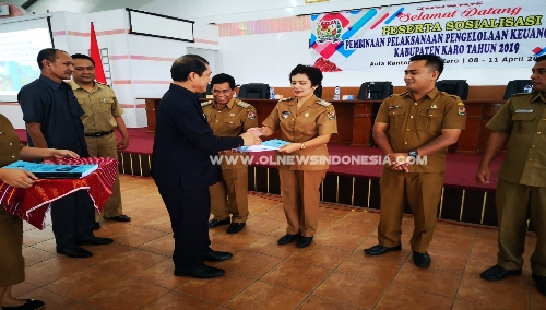 Ket foto : Bupati Karo Terkelin Brahmana SH saat menyerahkan buku secara simbolis tentang tata cara pembagian dan penetapan rincian Dana Desa Kepada salah satu Camat di Aula Kantor Bupati Karo, Kabanjahe, Senin (08/04) 2019