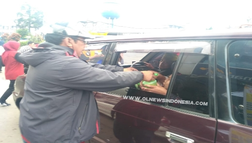 Ket foto  : Edwin Sembiring salah satu Alumni Smansagi Berastagi memberikan bingkisan Takjil kepada warga yang melintas, Minggu (02/06) 2019