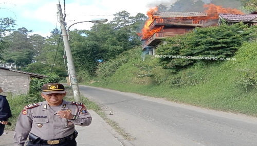 Ket foto  : Kapolsekta Berastagi AKP Pawang Ternalem Sembiring menghindar dari panas nya Api yang membakar Mess Purba Mergana dalam memantau kondisi kebakaran di puncak Gundaling Berastagi, Senin (08/07) 2019