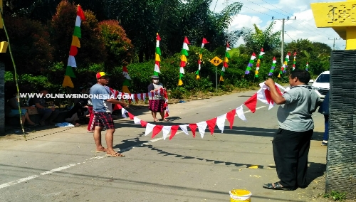 Ket foto  : Tampak Kepala Desa Dokan Martinus Sembiring (baju abu abu) bersama Mahasiswa USU memasang bendera dan umbul umbul untuk menyemarakkan HUT Ke 74 Republik Indonesia.