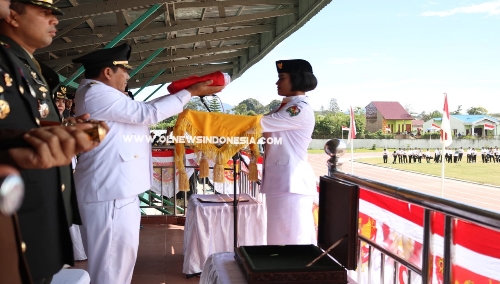 Ket foto : Bupati Karo Terkelin Brahmana sebagai Irup dalam HUT ke - 74 RI di Lapangan Samura Kabanjahe, saat menyerahkan Bendera Merah Putih kepada Paskibraka untuk di kibarkan, Sabtu (17/08) 2019.