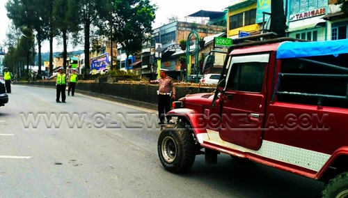 Ket foto : Kepala Pos lantas Berastagi ikut terjun memberhentikan setiap mobil yang lewat, Rabu (04/09) 2018 di Jalan Lintas Kabanjahe Berastagi.