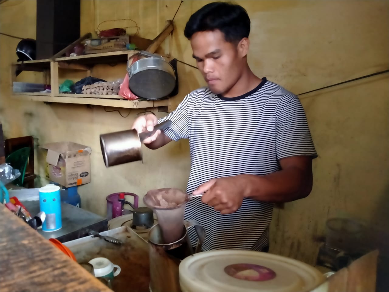 Ket foto  : Roberto Manik pemuda yang gigih dan rajin saat melayani pembeli di sebuah warung kopi tempatnya bekerja sebagai karyawan lepas untuk msngais Rezeki. (Ist)