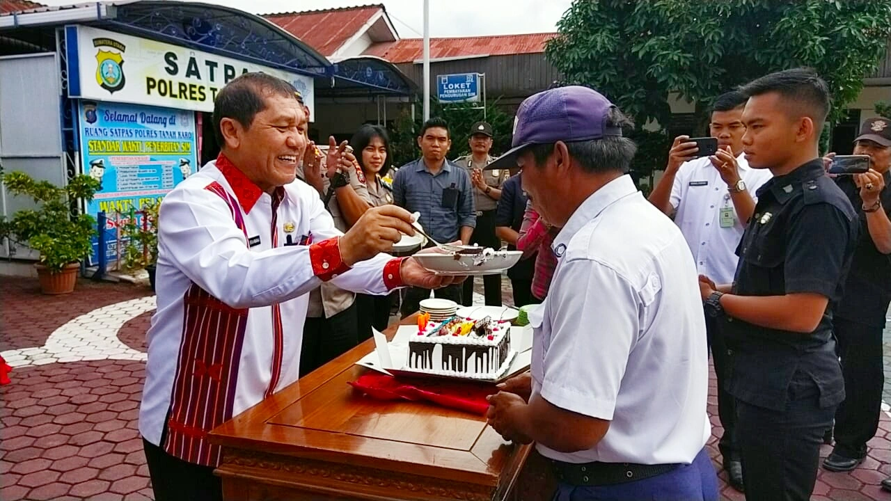 Ket foto : tampak Bupati Karo Terkelin Brahmana SH saat memberikan kue ulang tahun kepada salah satu Satpam pada acara HUT SATPAM KE-39 di Halaman Polres Tanah Karo, Rabu (22/01) 2020 (Ist)