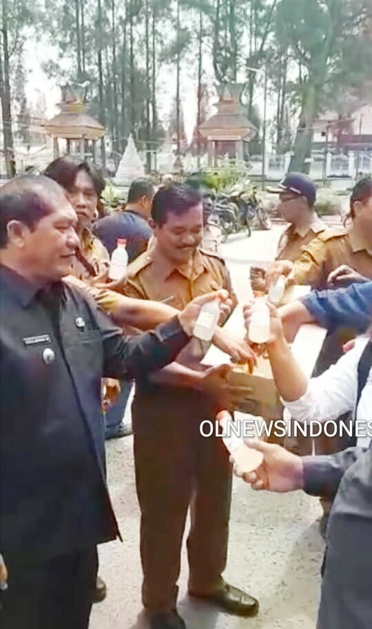 Ket foto : tampak Bupati Karo Terkelin Brahmana SH, MH, dan Kadis Pertanian Metehsa Purba  saat membagikan Hand Santizer ke warga di lingkungan Kantor Dukcapil Kabanjahe, Senin (30/03) 2020 (Ist)