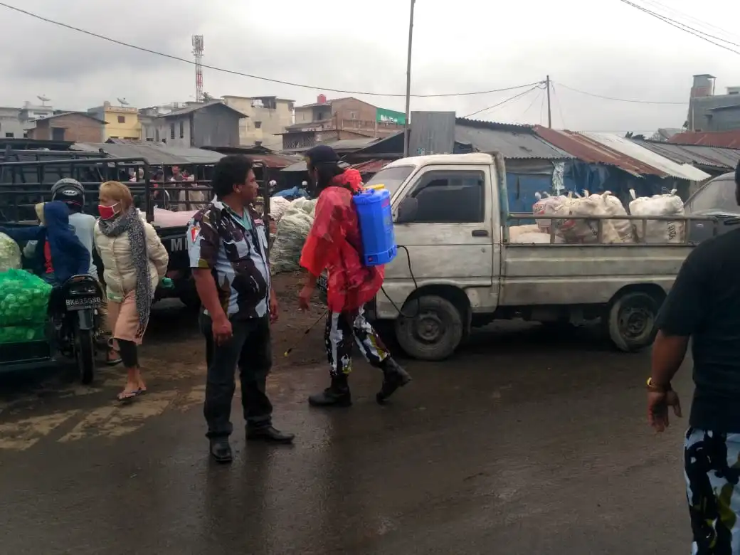 Ket foto : Sekretaris PAC Berastagi Tambak Tarigan saat memantau Anggota nya melakukan Penyemprot Desinfektan si Pusat sayur mayur pajak Roga Berastagi, Selasa (07/04) 2020 (Ist)