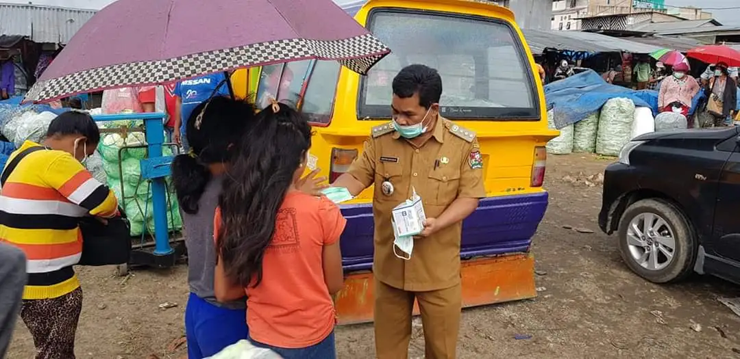 Ket foto : tampak Camat Berastagi Mirton Ketaren S.Sos sedang memberikan masker kepada masyarakat di pusat sayur mayur Pajak Roga Berastagi, Selasa) 14/04) 2020 (Ist)