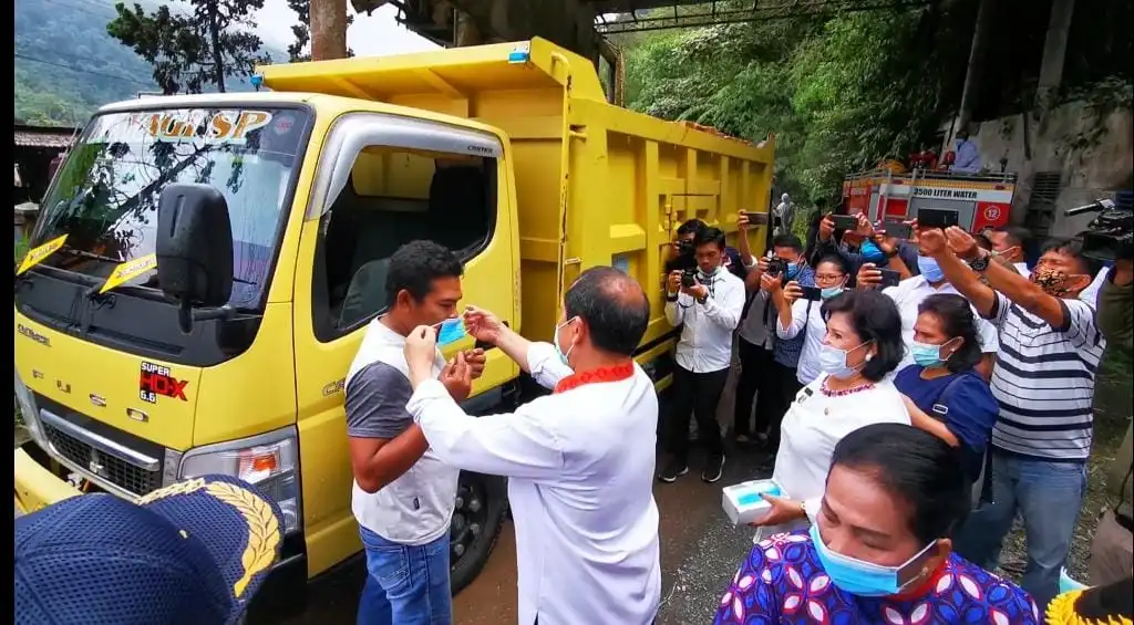 Ket foto : Bupati Karo Terkelin Brahmana SH, MH memakaikan Masker kepada  salah satu Supir truk sekaligus memberikan Edukasi terkait Covid-19 di Daulu Pasar Berastagi, Rabu (15/04) 2020 (Ist)