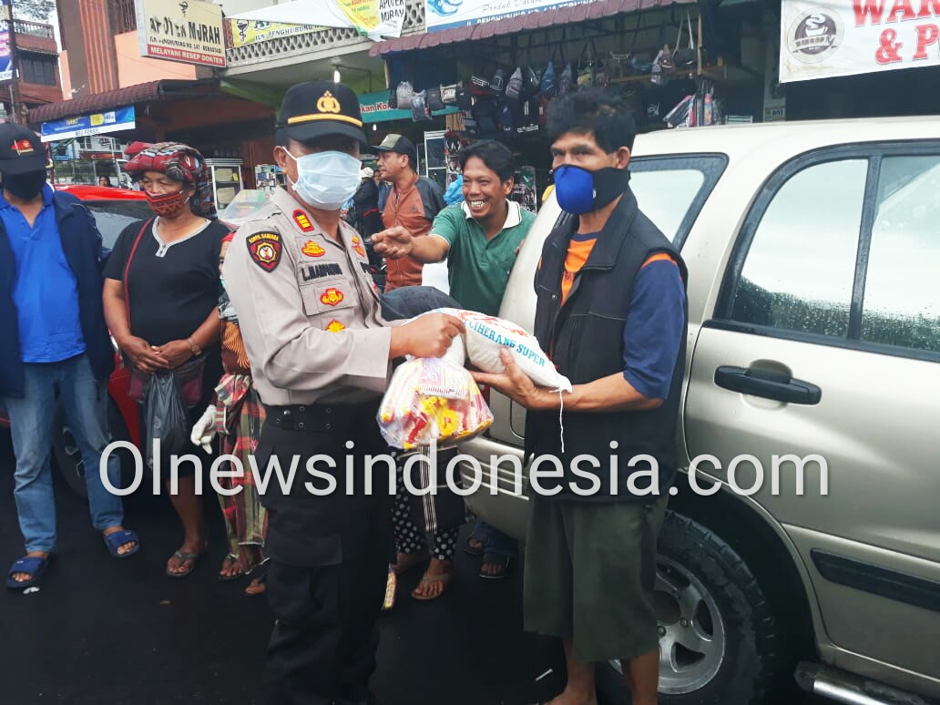 Ket foto : Kapolsekta Berastagi AKP L Marpaung memberikan paket Sembako kepada salah petugas Kebersihan di Berastagi Jumat (01/05) 2020 (Ist)