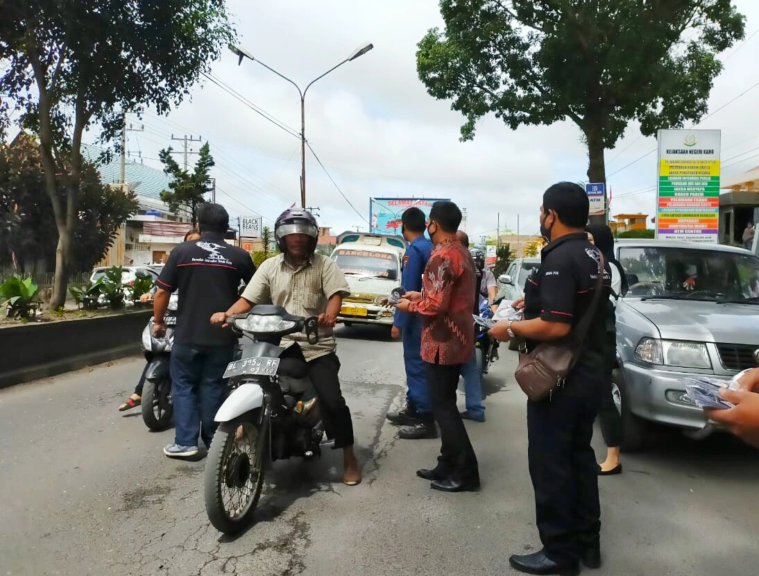 Ket foto : Kepala Kejari Kabupaten Karo Denny Ahmad SH MH saat turut membagikan masker ke para pengendara di Kabanjahe, Jumat (08/05) 2020 (Ist)