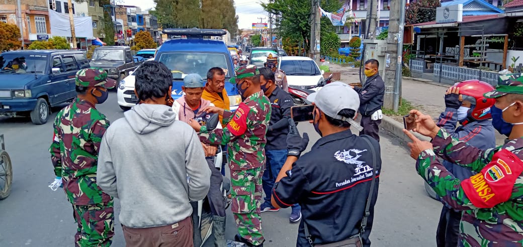 Ket foto : Pihak TNI dan Polri bersinergi dengan PJTK membagikan  masker di kota Berastagi, Jumat (08/05) 2020 (Ist)