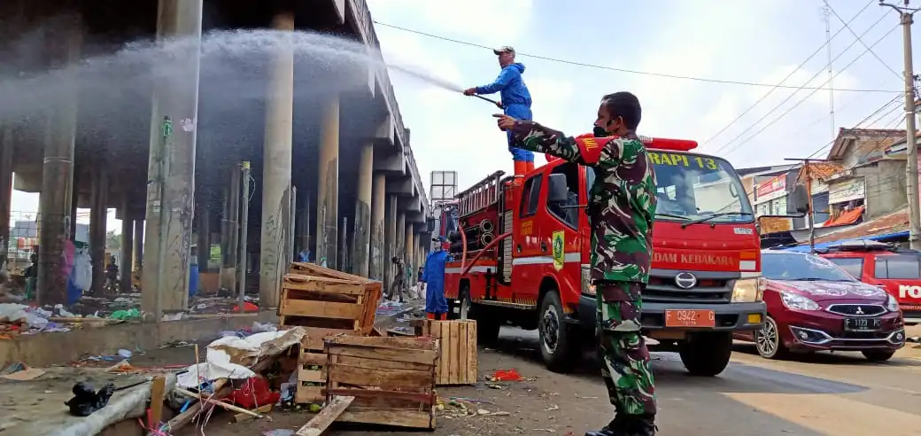 Ket foto: Saat Mayor Infantri Acep Komarudin, Danramil 2106 Cileungsi, dengan rasa antusiasnya, mengarahkan armada Damkar ketika Penyemprotan disinfektan berlansung, di fly over Cileungsi.