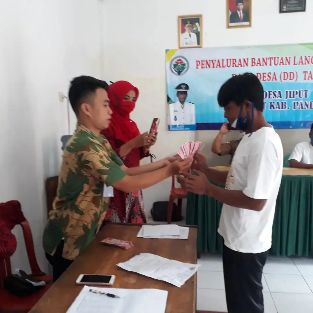 Ket poto : staf Desa memberikan Bantuan BST kepada masyarakat Desa Jiput.