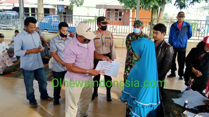 Ket foto : Kades Sempajaya Meliala Purba saat memberikan BLTDD kepada salah satu warga Desa Sempajaya di Jambur (Aula) Kamis, (28/05) 2020 (Ist)