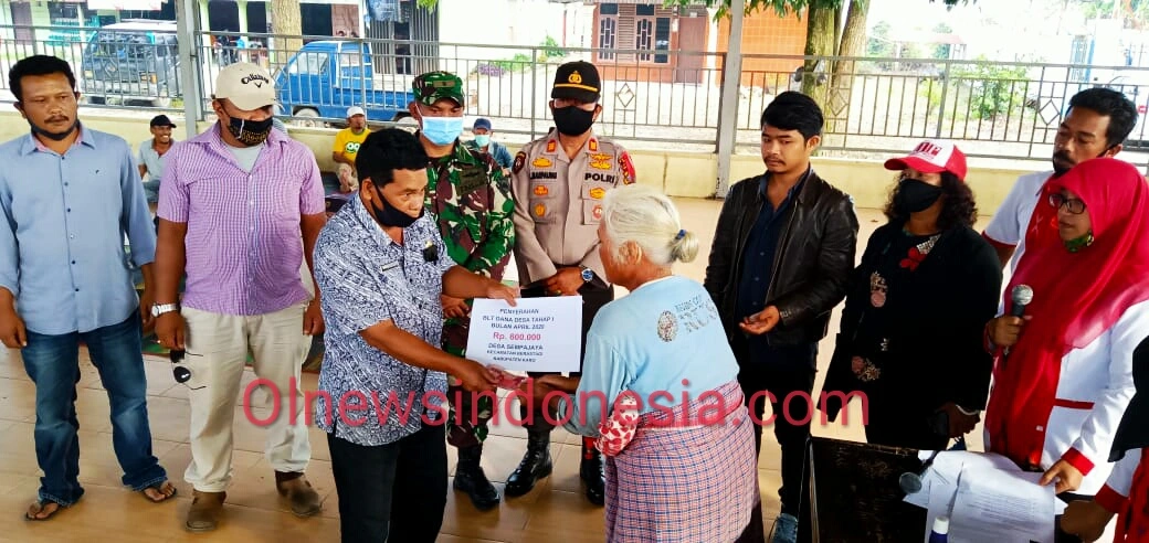 Ket foto : Tampak Camat Berastagi Mirton Ketaren S.Sos memberikan Dana BLTDD kepada salah satu warga di Jambur (Aula) Desa Sempajaya Peceren Berastagi Kabupaten Karo, Kamis (28/05) 2020 (Ist)