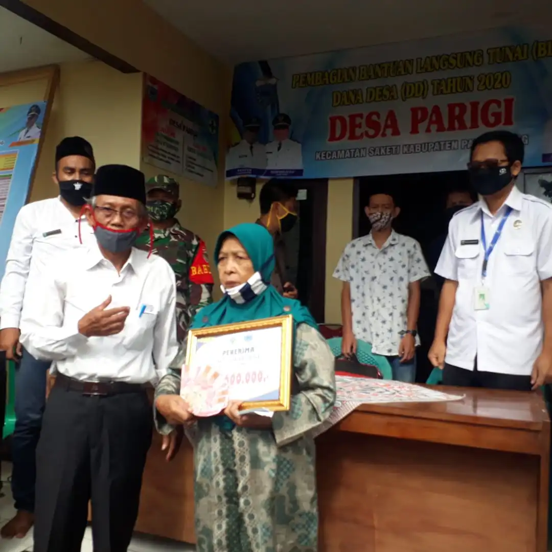 Foto : Mahpud Kepala Desa Parigi kecamatan Saketi (kiri berpeci) secara  simbolis memberikan  BLT kepada warganya yang terdampak Pandemi Covid-19 di Kantor Desa Parigi,Rabu(03/06)