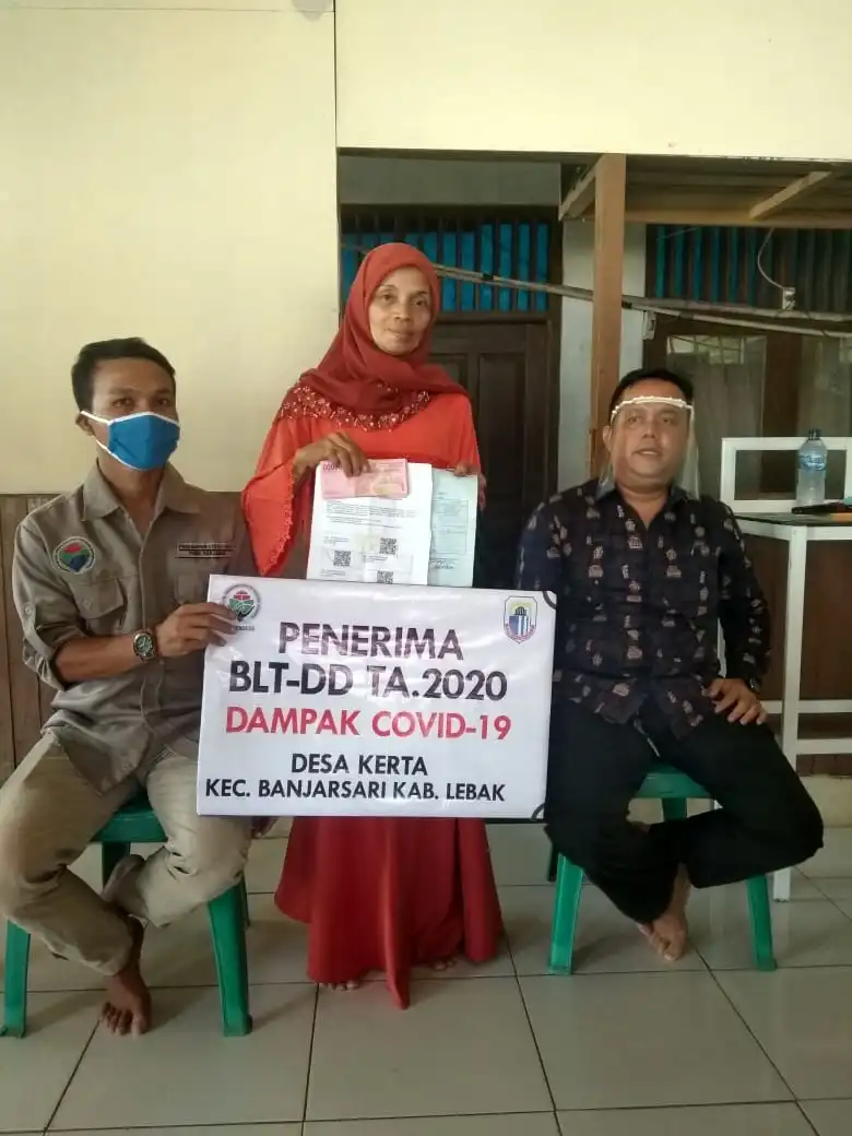 ket poto: Kepala Desa Kerta, H.Muhaemin berbaju batik memakai alat pelindung wajah sedang berfoto bersama warga penerima BLT DD,Jum'at (03/07/2020)