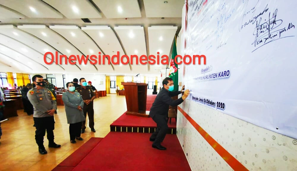 Ket foto : Terlihat Bupati Karo Terkelin Brahmana SH MH saat membubuhkan tanda tangan tanda mendukung dan berkomitmen dalam Deklarasi Cinta Damai untuk Tanah Karo di Aula Kantor Bupati Karo Kabanjahe pada, Senin (26/10) 2020 (Ist)