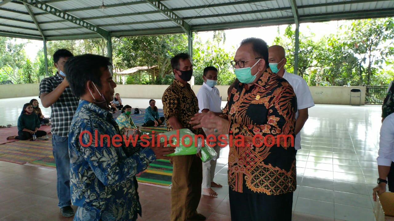 Ket foto  : tampak Ketua DPRD Sumut Baskami Ginting memberikan masker secara simbolis kepada salah satu Kepala Desa di Aula/Jambur Desa Batukarang, Rabu (11/11) 2020 (Ist)