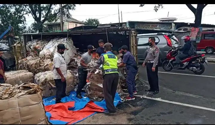 Ket foto: Kanit Lantas Polsek Cileungsi, Asep Saepudin( pojok kanan foto) berserta anggota dan warga, ketika evakuasi mobil truck yang terguling.