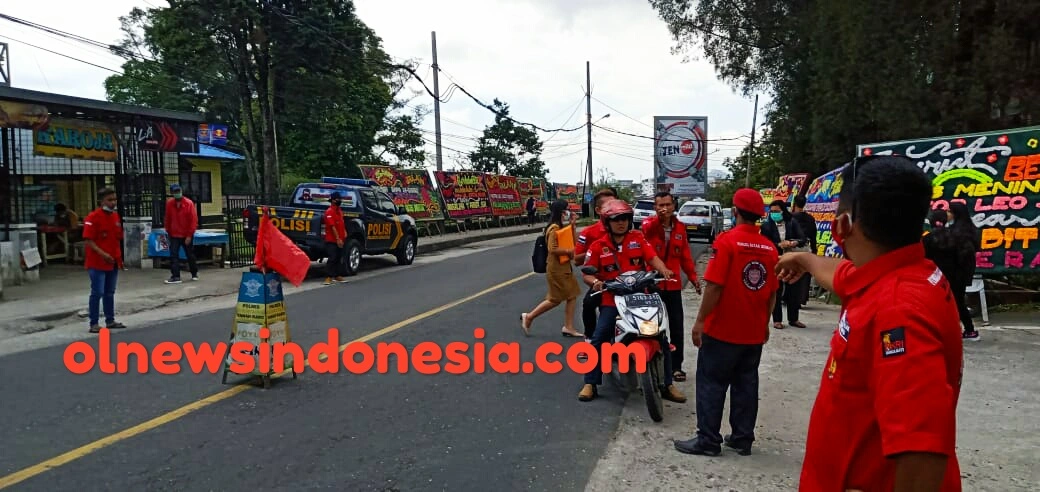 Ket Foto : tampak Pemuda Batak Bersatu PBB PAC Berastagi saat mengatur Lalu Lintas sepanjang jalan Medan-Berastagi di depan Gerbang Gereja Katolik Peceren Sempajaya Berastagi,Senin (01/03) 2021 (Ist)